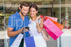 Young happy couple looking at mobile phone