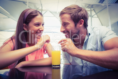 Young happy couple sharing a drink