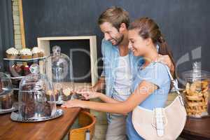 Young happy couple looking at muffins