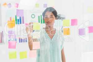 Concentrated businesswoman looking post its on the wall