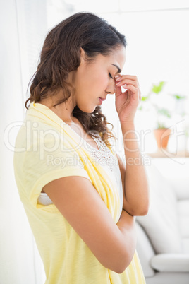 Young thinking business woman standing