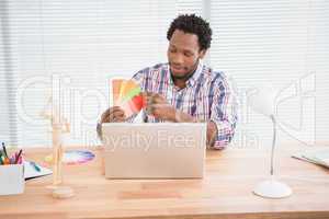 Young businessman looks at colourful cards