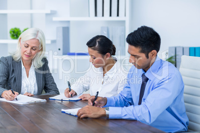 Business people writing on clipboards