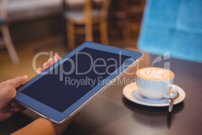 Close-up of digital tablet and coffee on table