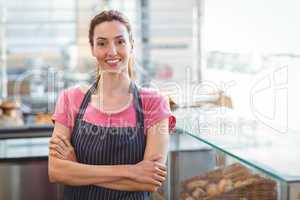 Smiling worker looking at camera with arm crossed