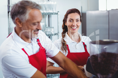 Pretty barista looking at camera and holding a mug of coffee