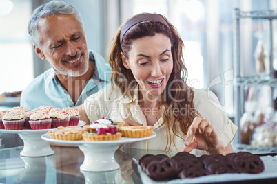 Cute couple choosing chocolate cakes