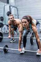 Muscular couple about to lift weights