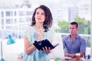 Thoughtful businesswoman holding a notebook