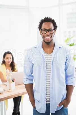 Smiling man posing in front of his colleague