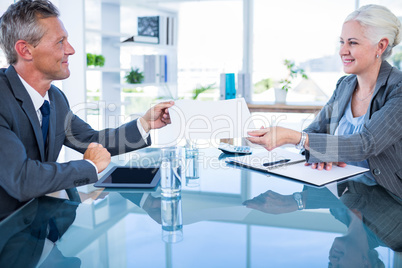 Businessman giving paper to hos colleague