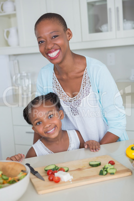 Portrait mother and daughter making a salad together
