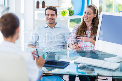 Pregnant woman and her husband discussing with doctor