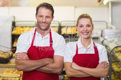 Portrait of smiling bakers with arms crossed