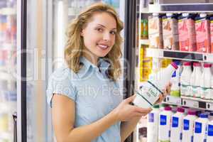 Portrait of a smiling woman having on her hands a milk bottle