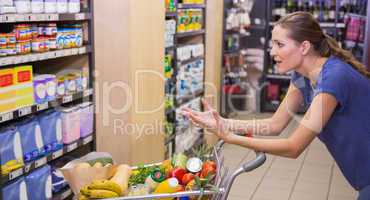 Surprised woman looking at product on shelf