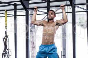 Muscular man doing pull up exercises