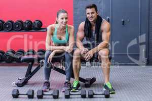 Muscular couple sitting on a bench