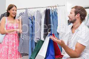 Smiling woman showing clothes to her man