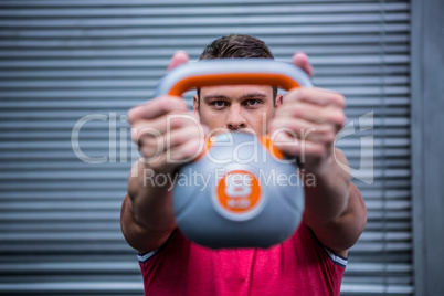 Muscular man lifting a kettlebell