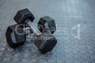 Two dumbbells lying on top of each other on the floor