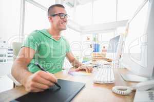 Young creative businessman drawing on graphic tablet