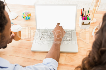 Colleagues using laptop and pointing the screen