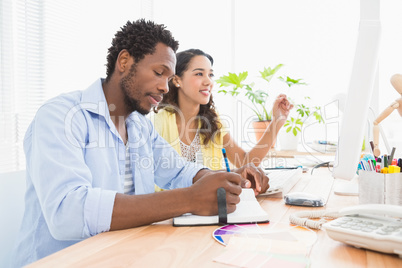 Man listening to colleague and taking notes