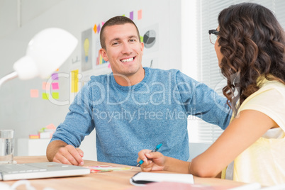 Smiling man speaking to his colleague and looking at camera