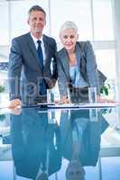 Business people looking at camera behind desk