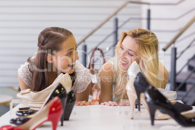 Two excited women looking at heel shoes