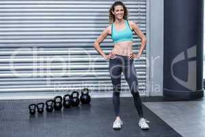 Standing muscular woman with hands on hips