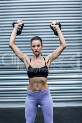 A muscular woman lifting kettlebells