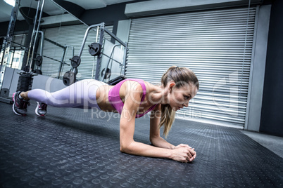 A muscular woman on a plank position