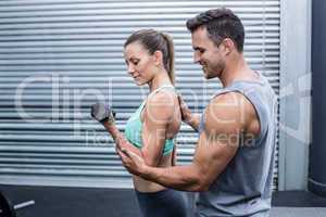 A muscular woman lifting dumbbells