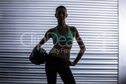 Muscular woman holding a medicine ball