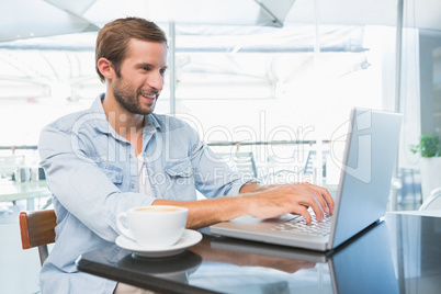 Young happy man typing on the laptop