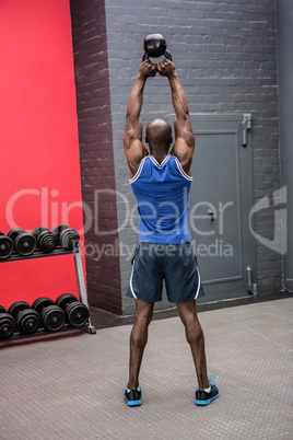 Back view of muscular man lifting a kettlebell