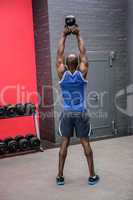 Back view of muscular man lifting a kettlebell