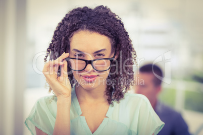 Pretty businesswoman tilting her reading glasses