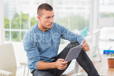 Young creative businessman looking at his tablet