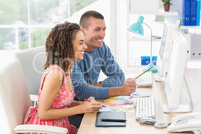 Creative business colleagues working on computer