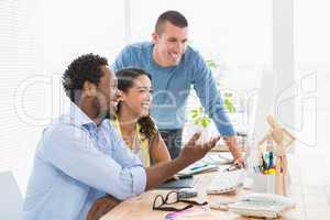 Smiling coworkers using computer together