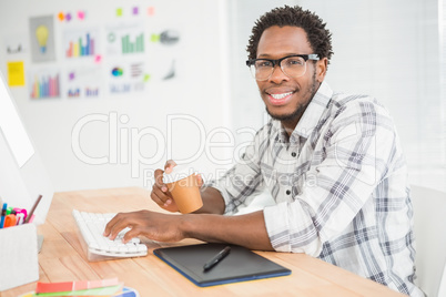 Portrait of smiling casual businessman working with computer and