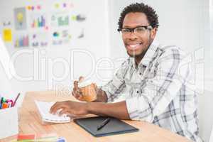 Portrait of smiling casual businessman working with computer and