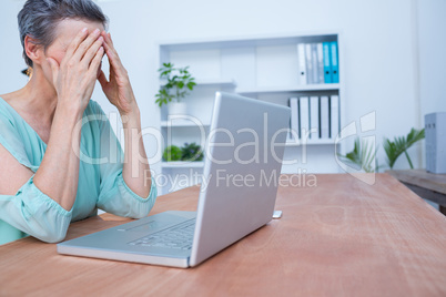 Worried businesswoman in front of her laptop