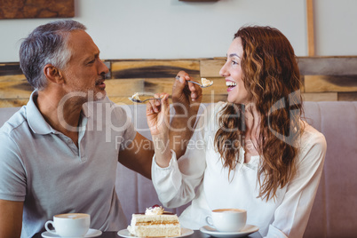 Casual couple having coffee and cake together