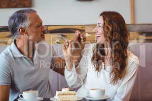 Casual couple having coffee and cake together