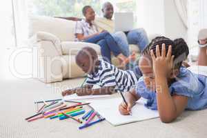 Happy siblings on the floor drawing