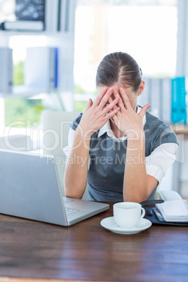 Depressed businesswoman with hands on head